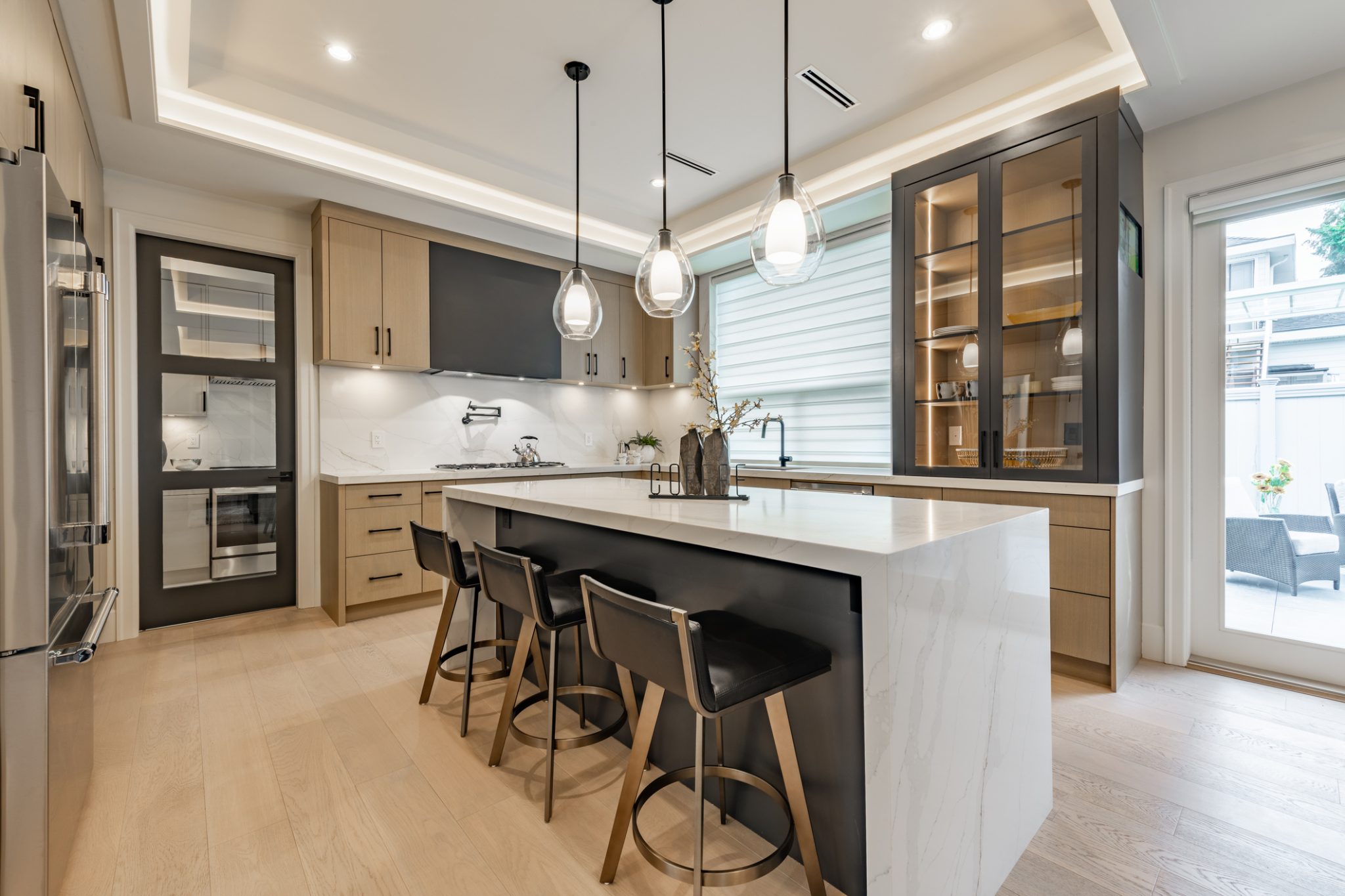 Modern kitchen interior with sleek cabinetry, pendant lights, and large island countertop.